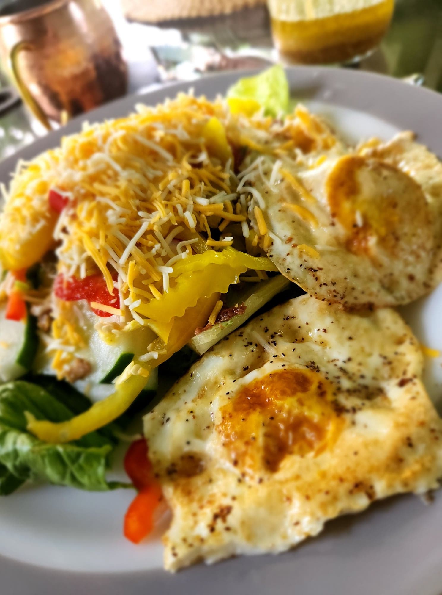 Loaded Veggie Salad with cheese and two fried eggs